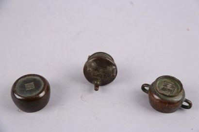 null Suite de trois petits pots en bronze, marques au dessous. H. 5,5 - 3,5 - 3 ...