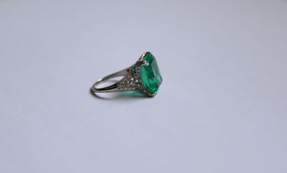 null Platinum ring set with an emerald-cut Colombian emerald weighing approximately...