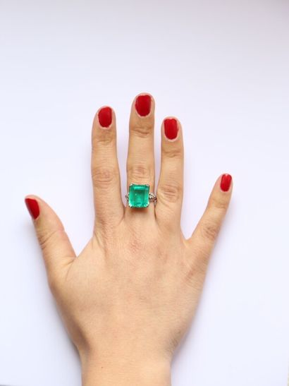 null Platinum ring set with an emerald-cut Colombian emerald weighing approximately...