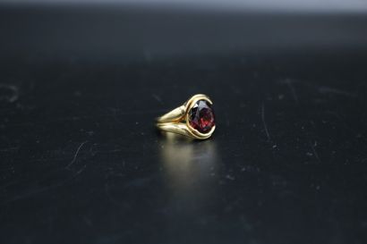 null Ring in yellow gold 750 thousandths decorated with an oval brilliant cut garnet....