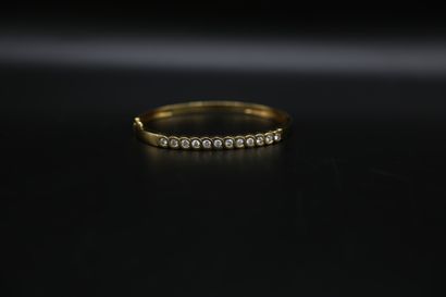 null Bracelet jonc ouvrant en or jaune (750) orné de douze diamants ronds brillants...