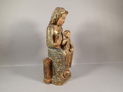 null Vierge à l'Enfant en bois sculpté, polychromé et doré. Assise sur un banc trône,...