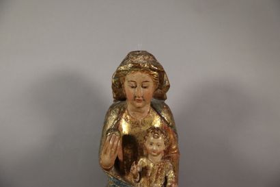null Vierge à l'Enfant en bois sculpté, polychromé et doré. Assise sur un banc trône,...