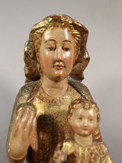 null Vierge à l'Enfant en bois sculpté, polychromé et doré. Assise sur un banc trône,...