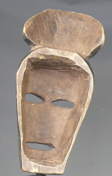 null Masque en bois patiné figurant un visage ovale stylisé surmonté d'une coiffe...