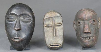 null Trois masques en bois léger patiné, l'un Makonde de type naturaliste à la bouche...
