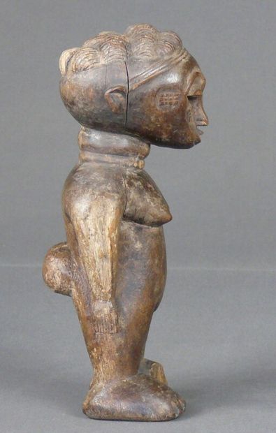 null Hardwood statuette with natural patina showing a stocky female figure, standing,...