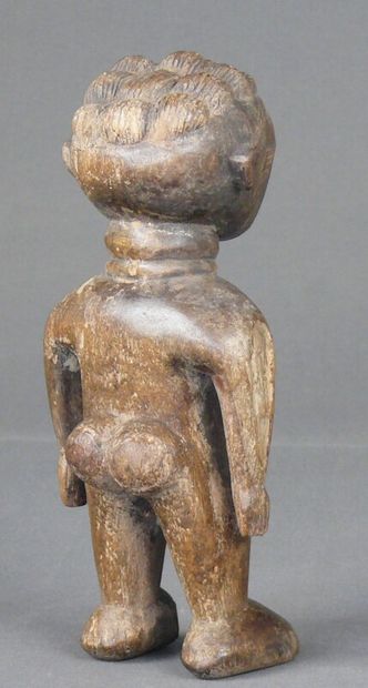 null Hardwood statuette with natural patina showing a stocky female figure, standing,...
