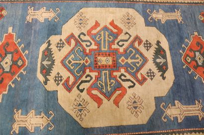 null Tapis en laine à décor polychrome de motifs géométriques sur fond bleu, le médaillon...