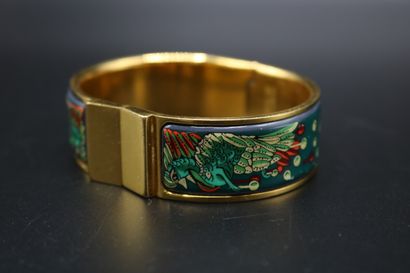 null Hermès, rigid opening bracelet, in gilded metal and printed enamel with a peacock...