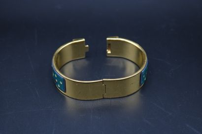 null Hermès, rigid opening bracelet, in gilded metal and printed enamel with a peacock...