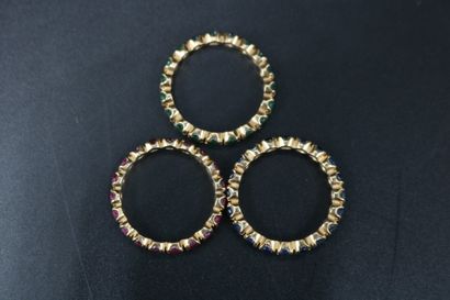 null Trois anneaux en or jaune 750 millièmes ornés de pierres de couleurs : le premier...
