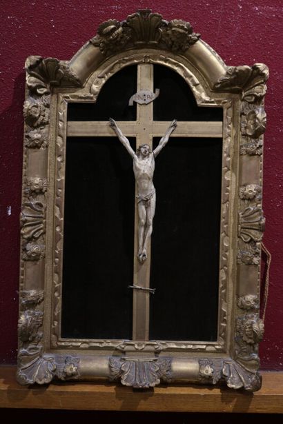 null Un crucifix dans un encadrement en bois doré mouluré et sculpté. 

Fin XVIIIe...
