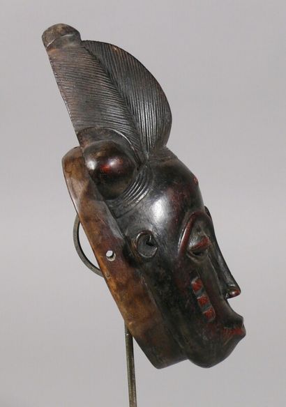 null Hardwood mask with a dark patina and traces of pigments depicting a face with...