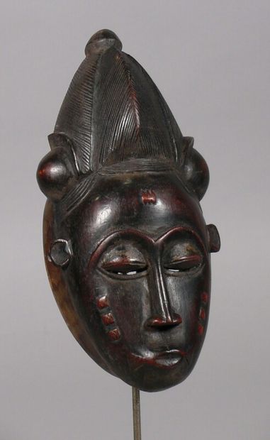 null Hardwood mask with a dark patina and traces of pigments depicting a face with...