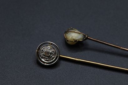 null Two yellow gold tie pins, one with a baroque pearl and the other with a round...