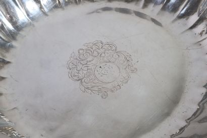 null Round silver bowl with gadrooned ribs, resting on a flat bottom. The center...