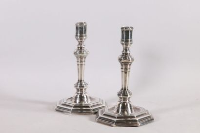 null Pair of silver candlesticks with sides resting on an octagonal base with steps...