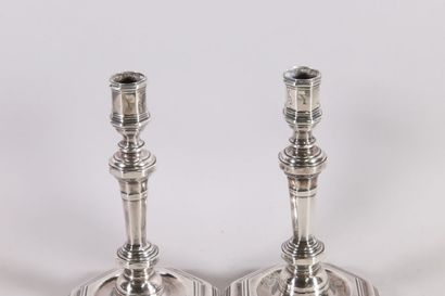 null Pair of silver candlesticks with sides resting on an octagonal base with steps...