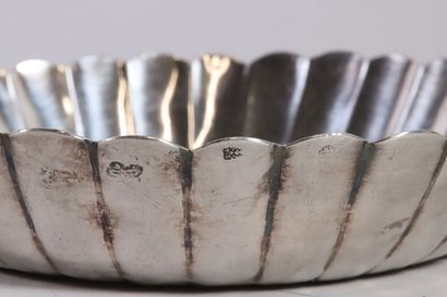 null Round silver bowl with gadrooned ribs, resting on a flat bottom. The center...