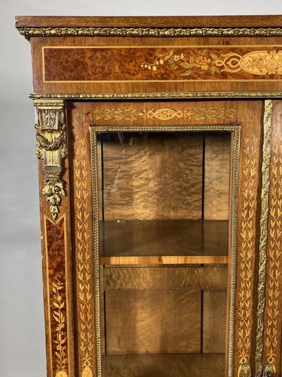 null Rectangular display cabinet in veneer wood opening by two glass doors, decorated...