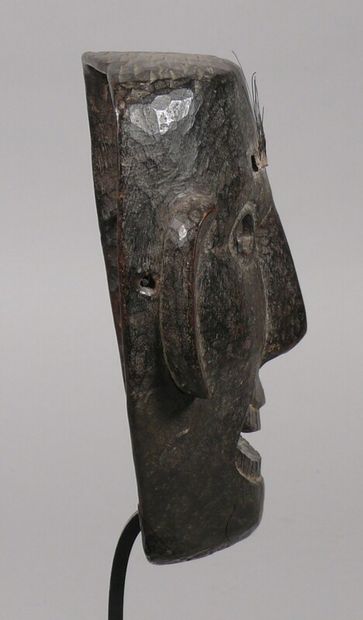 null Hardwood dance mask with dark patina of use showing a large smiling face, the...