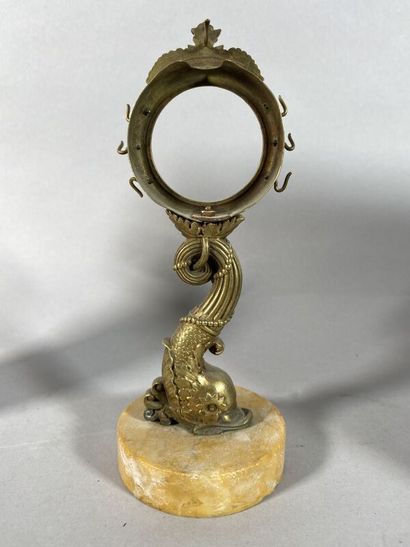 null A gilt bronze watch-holder decorated with a dolphin, on a marble base
H. 18...