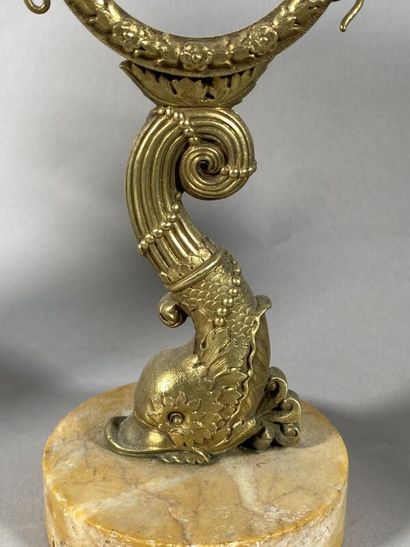 null A gilt bronze watch-holder decorated with a dolphin, on a marble base
H. 18...