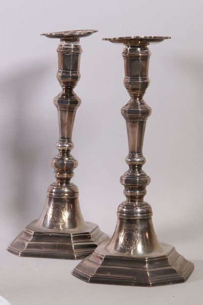 null Pair of silver candlesticks with sides, resting on an octagonal base with steps...