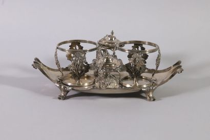 null Oil cruet in silver with scrolls. The bottle holders decorated with vine stocks.
The...