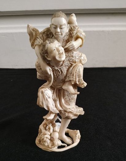 null CHINE Groupe en ivoire sculpté et gravé à décor de deux personnages. Vers 1930...