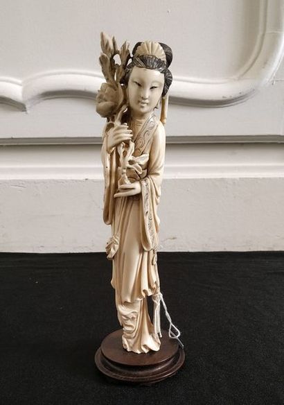 null CHINE Statuette en ivoire à personnage féminin tenant une pivoine. Vers 1930...