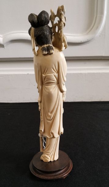 null CHINE Statuette en ivoire à personnage féminin tenant une pivoine. Vers 1930...