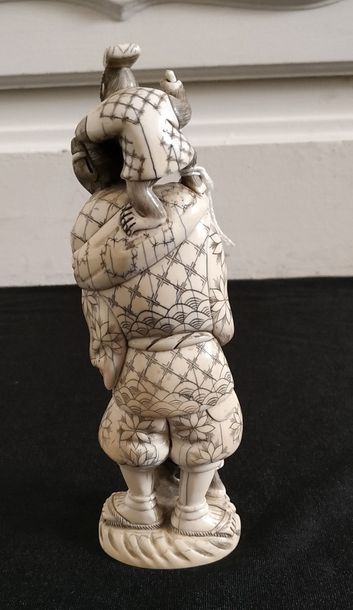 null CHINE Groupe en ivoire sculpté et gravé représentant un montreur de singes....