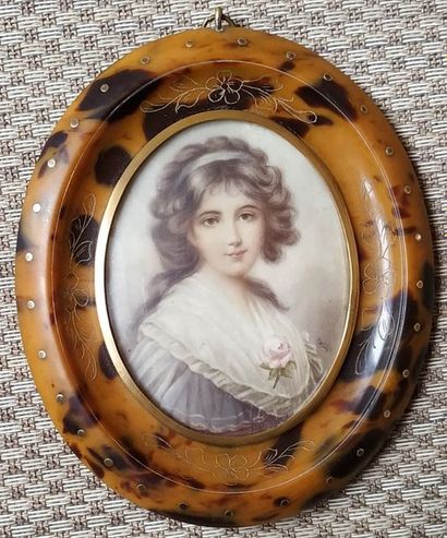 null Oval MINIATURE on ivory representing the bust of a young woman with a rose....