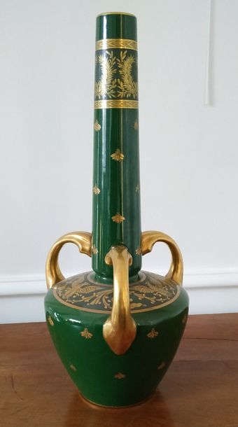 null A large vase with a long neck in green enamelled ceramic with golden bee decorations...