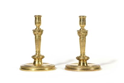  Pair of gilt bronze candleholders, the chiselled binets of water leaves, the tapered...