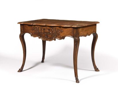  TABLE de forme mouvementée en bois naturel mouluré et sculpté de volutes, de fleurettes...