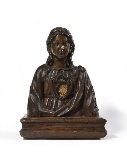 Reliquary bust of a holy woman in wood carved in the round. With a full face, her...