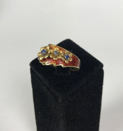 null RING in yellow gold holding a belt of mobile flowers set with blue stones, the...