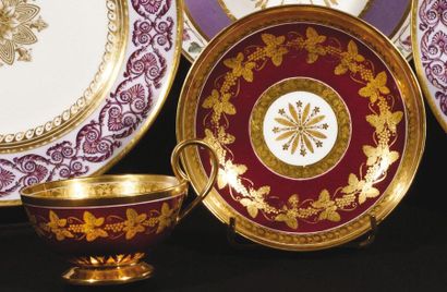 null Sèvres Tasse à thé et sa soucoupe en porcelaine à décor en or sur fond pourpre...
