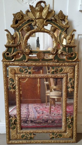 null MIRROR WITH PARECLOSES in gilded wood and green lacquered, the animated pediment...