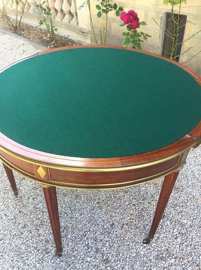 null GAME TABLE in mahogany half-moon with a brass ring, opening on the top by two...