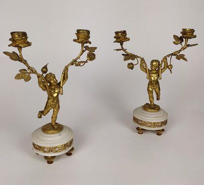 null Pair of ormolu and chiselled bronze candelabra with Amours decoration holding...