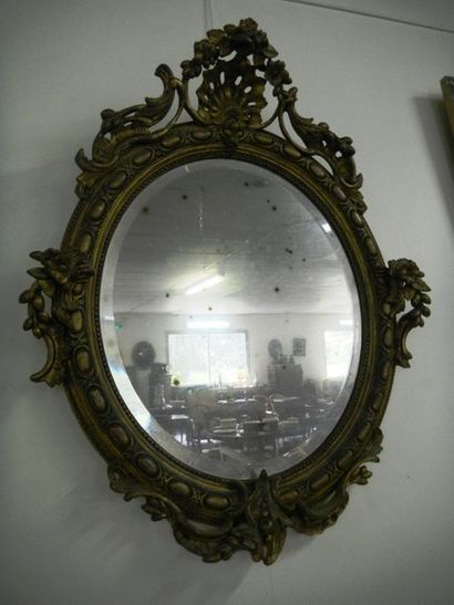 null Miroir ovale de style Louis XV en bois et stucs dorés à décor de coquille, fleurs,...
