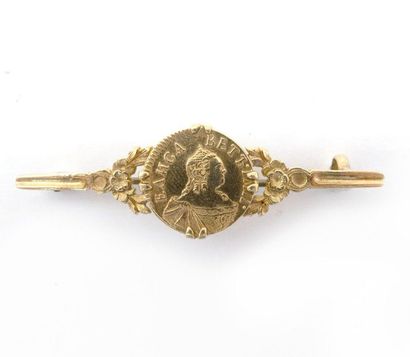 18K yellow gold brooch (metal pin) holding...