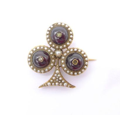 null 18K yellow gold brooch decorated with three garnet cabochons and a multitude...