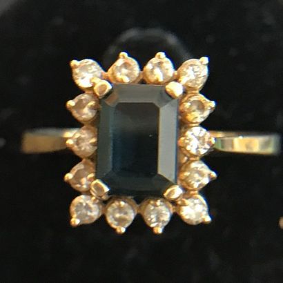 null RING in 14k yellow gold adorned with an emerald-cut sapphire surrounded by small...