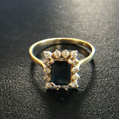 null RING in 14k yellow gold adorned with an emerald-cut sapphire surrounded by small...