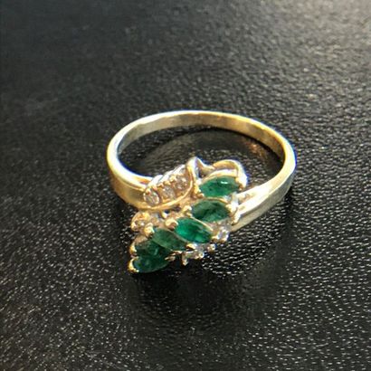 null RING in 14k yellow gold with a line of shuttle-cut emeralds flanked by small...